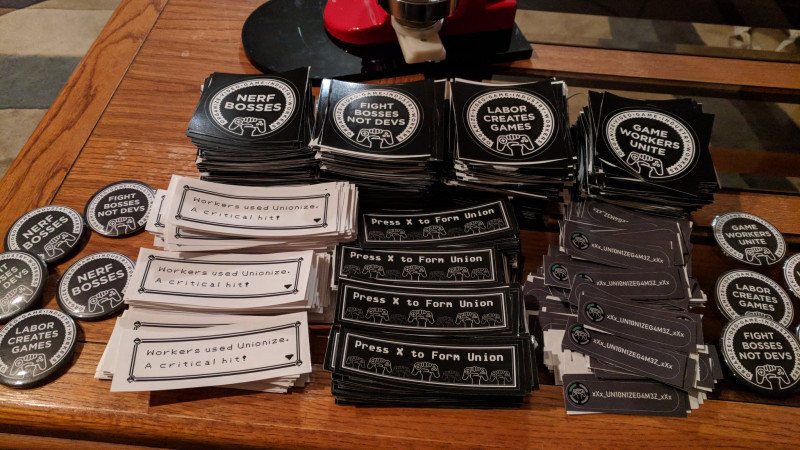 GWU stickers and badges at an expo. Night in the Woods co-creator Scott Benson designed the GWU's main logo